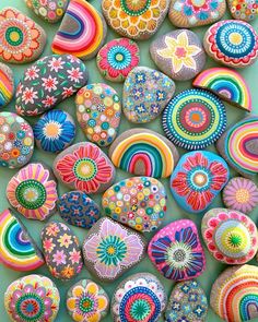 many colorful rocks are arranged together on the table and one is painted with different colors