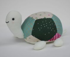 a small stuffed animal with a green and white turtle on it's back