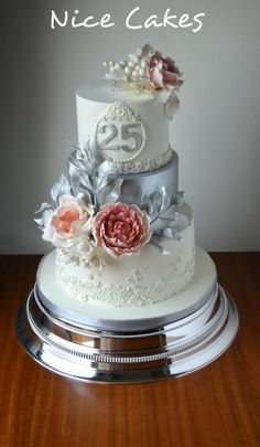 a three tiered cake with white frosting and pink flowers