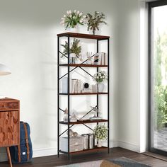 a book shelf with plants and books on it in front of a sliding glass door