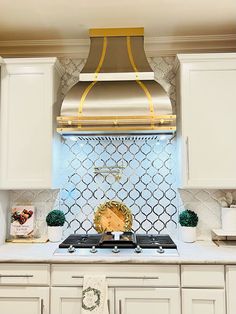 a stove top oven sitting inside of a kitchen next to white cabinets and counter tops