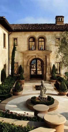 a large house with a fountain in the front yard