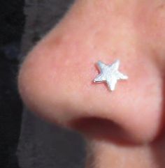 a close up of a person's nose with a small silver star on it