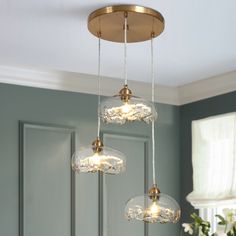 three lights hanging from a ceiling in a room