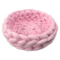 a pink basket that is sitting on top of a white surface with braiding around it