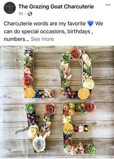 the word g is made out of flowers and fruit on top of a wooden table