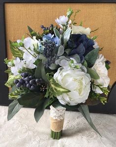 a bouquet of flowers sitting on top of a table next to a framed piece of artwork