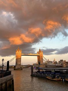 the tower bridge in london is lit up at sunset