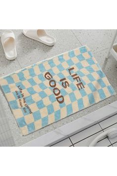 a blue and white checkered door mat with the words good life on it