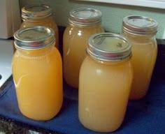 four jars filled with liquid sitting on top of a blue mat next to a microwave