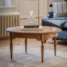 a coffee table with a book on it in front of a couch and radiator