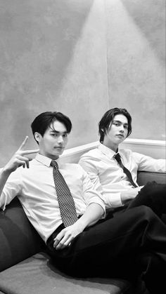 two young men sitting on top of a couch