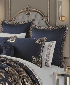 a bed with blue and gold comforters on it