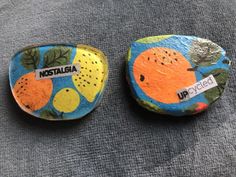 two painted rocks sitting on top of a gray surface