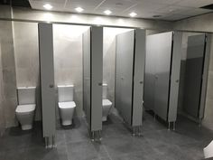 a public restroom with stalls and urinals on the walls, all in stainless steel