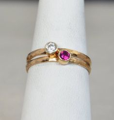 "Grab 2 Hammered 14k Rose Gold Filled stackable mothers rings with birthstones of your choice. Simple, rustic, Everyday Ring. Perfect for a flash of gold and color on the hand, without being to \"much.\" - High quality 14k rose gold fill bands, and Solid 14k gold bezels. - 3mm Lab grown gemstones. Natural Stones Available. - Delicate hand-hammered texture. - Made to order, just for you. **When you place your order indicate the 2 birth months you want in the note to seller box at checkout.** If y Adjustable Rose Gold Stackable Birthstone Ring, Adjustable Rose Gold Birthstone Ring With Round Band, Adjustable Stackable Rose Gold Birthstone Ring, Rose Gold Gemstone Stackable Anniversary Rings, Adjustable Stackable Ruby Ring For Anniversary, Adjustable 14k Gold Ruby Ring For Anniversary, Adjustable Rose Gold Stackable Rings Round Cut, Rose Gold Adjustable Stackable Rings, Stackable Rose Gold Birthstone Ring With Round Band