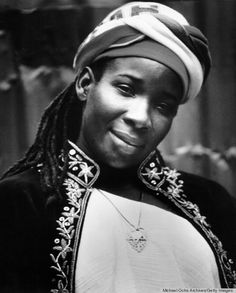 a black and white photo of a woman with dreadlocks on her head wearing a turban