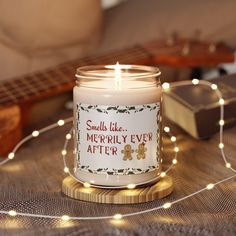 a lit candle sitting on top of a wooden table next to a string of lights