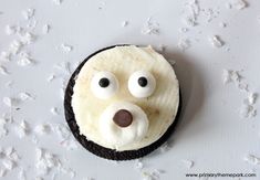 a cookie with icing and googly eyes in the shape of a dog's head