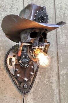 a skull wearing a cowboy hat with gears attached to it's face and light bulb