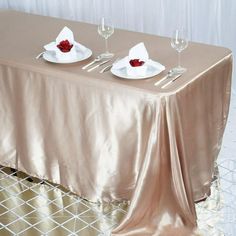 the table is set with two white plates and silverware