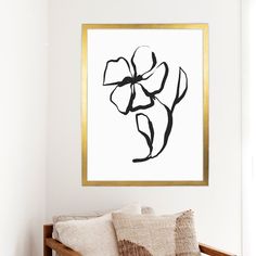 a black and white painting hanging on the wall next to a wooden bench with pillows