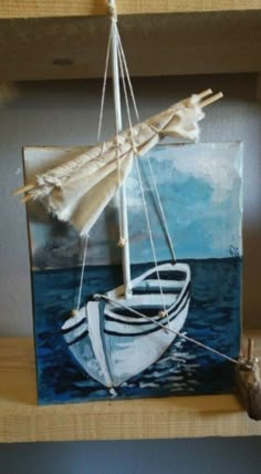 a painting of a sailboat on a shelf