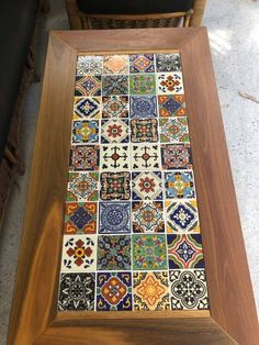 a wooden table topped with lots of colorful tiles on it's sides and bottom