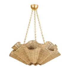 a chandelier made out of straw with gold chains hanging from it's center