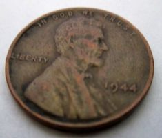 an old penny with the image of liberty on it's back side, sitting on a white surface