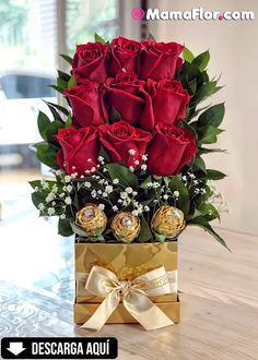 a bouquet of red roses and chocolates in a gold gift box on a table