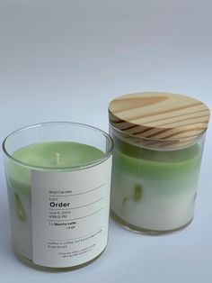 a green candle with a wooden lid next to it