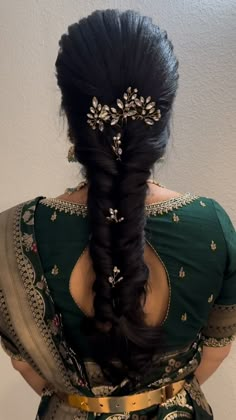 a woman with long black hair wearing a green sari