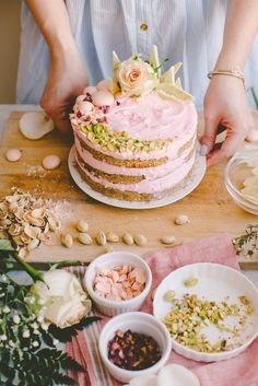 a woman is decorating a cake with pink frosting