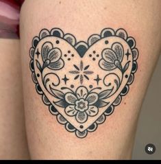 a woman's thigh with a heart tattoo on it