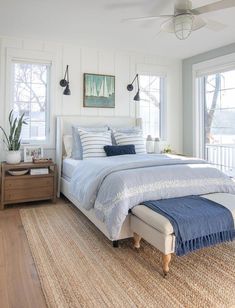 a bedroom with white walls and blue bedding