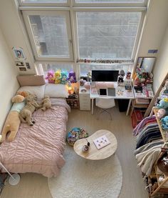 an aerial view of a bedroom with lots of stuffed animals on the bed and desk