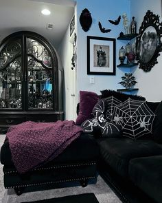 a living room filled with black furniture and pictures on the wall above it's headboard