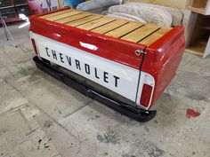 a red and white truck with the word chevrolet written on it's back tire