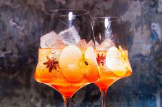 two wine glasses filled with fruit and ice