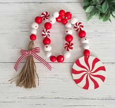 a red and white bracelet with candy canes on it next to a round ornament