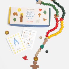 an assortment of wooden beads and magnets on a white surface with a book in the background