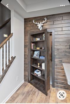 an open bookcase in the corner of a room with wooden walls and flooring