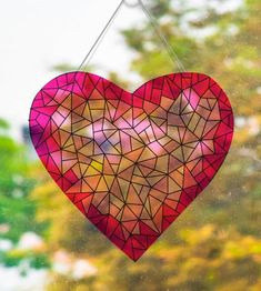 a stained glass heart hanging from a window