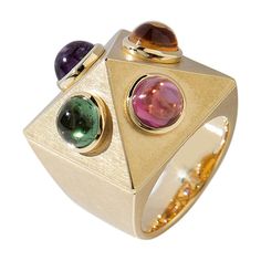 This "Pyramid Ring" made of yellow gold with one each amethyst, citrine, tourmaline and garnet cabochons impresses with its exceptional design by Wagner Preziosen. Wear it and show off! Ring Size as ordered. Shipping: 8 weeks from order date. Luxury Silver Amethyst Ring Modern Style, Yellow Gold Multi-stone Cabochons For Fine Jewelry, Yellow Gold Multi-stone Cabochons Fine Jewelry, Modern Gold Multi-stone Gemstones, Yellow Gold Multi-stone Cabochons For Gift, Fine Jewelry Multi-stone Cabochons As Gift, Fusion Style Multi-stone Yellow Gold Gemstones, Yellow Gold Multi-stone Fusion Gemstones, Multi-stone Tourmaline Gemstones