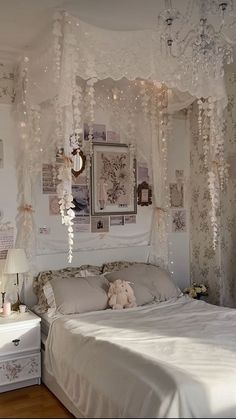 a white bed sitting in a bedroom under a chandelier