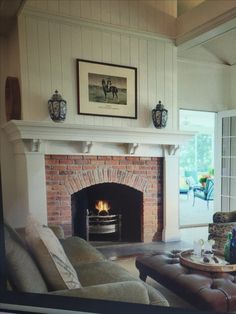 a living room filled with furniture and a fire place under a painting on the wall