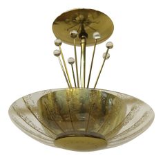 a glass bowl with metal rods sticking out of it's center and two lights on each side