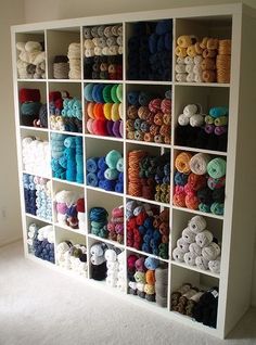 a shelf filled with lots of different colored yarn