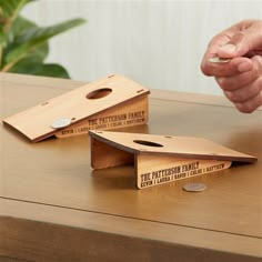 two wooden business card holders sitting on top of a table next to each other, one with a hole in the middle